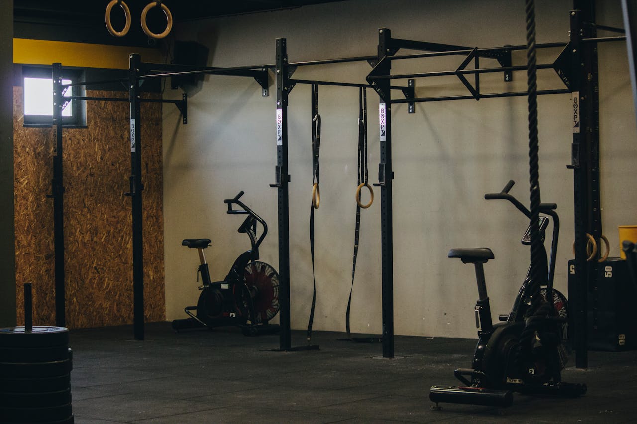 services-02 Industrial-style gym with exercise bikes, rings, and pull-up bars in Angola.