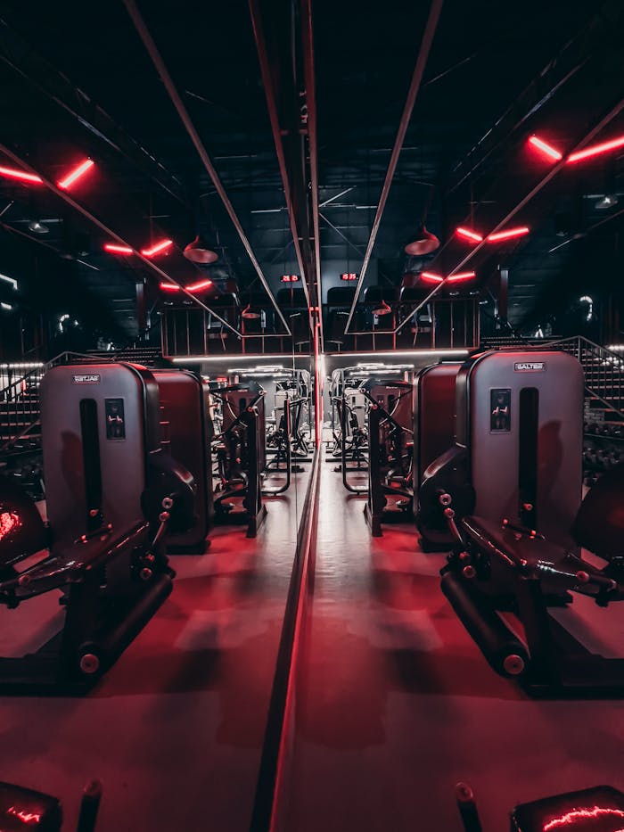 services-03 Fitness center with sleek gym equipment and red neon lights creating a futuristic ambiance.